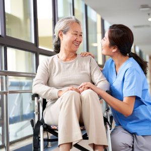 Friendly,Staff,Caregiver,Of,Nursing,Home,Talking,To,Asian,Senior